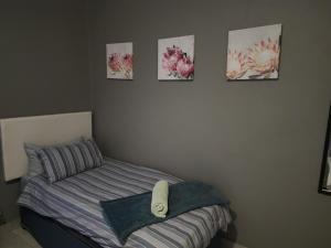 内尔斯普雷特Le Grix Guesthouse的卧室配有一张床,墙上挂有四张照片