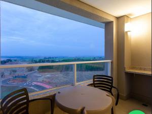 奥林匹亚Resort Solar das Águas的客房设有桌椅和大窗户。