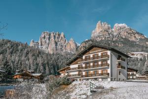 PeraHotel Garnì Rosengarten的山间酒店,背景是山脉