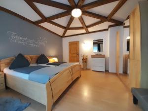 上柯尼希山麓米尔巴赫Haus Rosina的一间卧室设有一张带木制天花板的大床