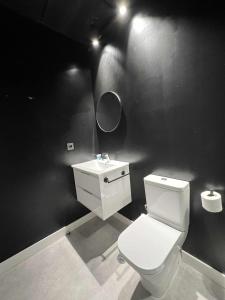 马拉加Hostel Faro Málaga modern & luxury的浴室配有白色卫生间和盥洗盆。