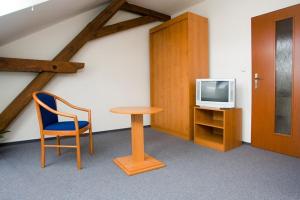 赫拉德茨 - 克拉洛韦斯梅坦努斯塔特科宾馆的配有桌子、椅子和电视的房间