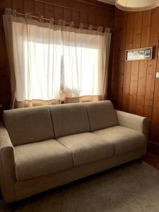 科尔蒂纳丹佩佐Relax a Cortina d'Ampezzo - Alverà的客厅设有一张沙发,配有窗户