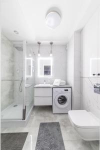 比亚韦斯托克ResiNest Apartamenty Kopernik的白色的浴室设有洗衣机和水槽。