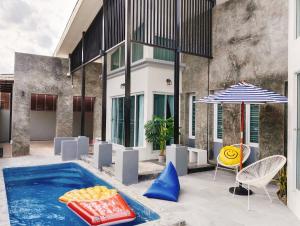 Ban Bang Rin (1)Nadda Pool Villa Ranong的一个带桌椅和遮阳伞的游泳池