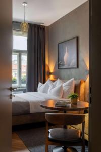 布拉格The Viaduct - Suites & More的酒店客房设有床、桌子和窗户。