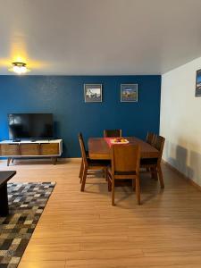 墨西哥城锡那罗亚46公寓的客厅配有桌椅和电视。