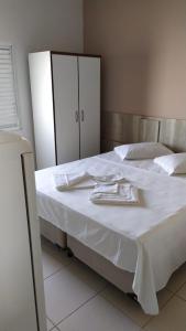 伊塔尼亚恩Hotel Pousada Miami的一张带白色床单和餐具的床