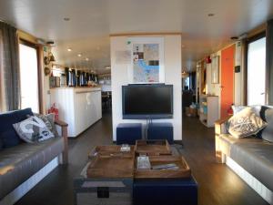 阿姆斯特丹爱丽丝船屋的客厅配有两张沙发和一台电视机