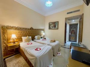 突尼斯Royal Victoria - Ex British Embassy的酒店客房,配有两张带白色床单的床
