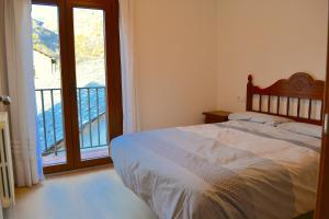 埃斯特里-德阿内乌Apartament comfortable amb vistes i cèntric by RURAL D'ÀNEU的一间卧室设有一张床和一个阳台的窗户。