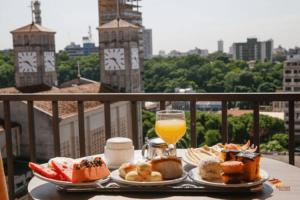 库亚巴马托格罗索皇宫酒店 的一张桌子,上面放着两盘食物和一杯橙汁