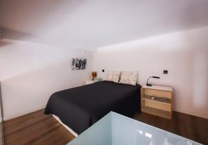 马德里Tofi的一间卧室配有一张黑色的床和一张桌子