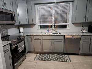 PikevilleSpacious Family Farmhouse的厨房配有白色橱柜、水槽和炉灶。