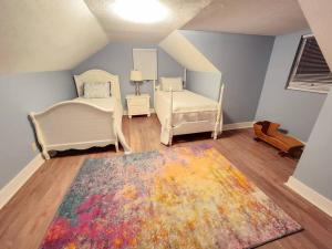 PikevilleSpacious Family Farmhouse的一间卧室配有两张床和一张色彩缤纷的地毯。