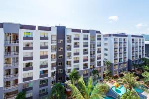 华欣First Hua Hin - Ji Ya的公寓大楼设有游泳池和棕榈树