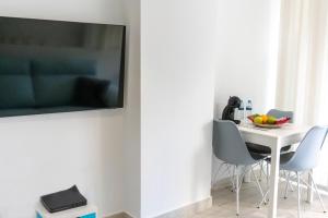 美洲海滩El Dorado 114 luxury with full air-conditioning的一张带椅子的白色桌子和墙上的电视