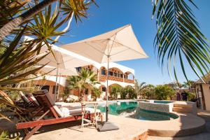 El Pescadero奥拉塞德丽托斯酒店的游泳池旁的白色遮阳伞