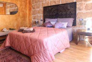 贝尼萨Casa Marrón Boutique Home的一间卧室配有一张带粉红色棉被的床