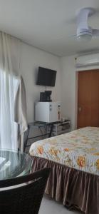 伊利亚贝拉Suite Ilhabela - com varanda e vista panorâmica的酒店客房设有一张床铺和一张玻璃桌