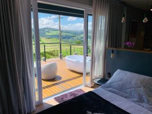本图贡萨尔维斯Vista Vigneti Albergo & Vino - Vale dos Vinhedos的一间带浴缸的卧室和一个美景阳台
