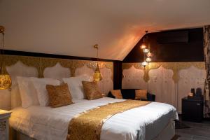 宗奥芬B&B 1001 nacht的卧室配有带金色枕头的大型白色床