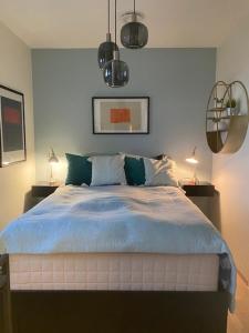 克里斯蒂安桑Kongens Apartment St Joseph的一间卧室配有一张带蓝色床单的床和两盏灯。