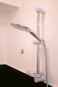 BalangaGrand Peninsula Suites的白色的客房设有带花洒淋浴头的淋浴间。
