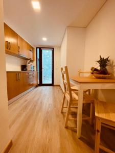 丰沙尔Living Funchal X的厨房以及带桌椅的用餐室。