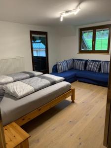 格绍Ferienwohnung Schmaranzer的客厅配有两张床和蓝色的沙发