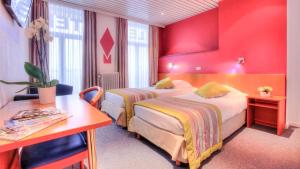 蒙斯特米努斯酒店的红色墙壁的酒店客房内的两张床