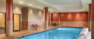 亚特兰大亚特兰大坎伯兰万怡酒店/画廊的一座带椅子和桌子的酒店游泳池