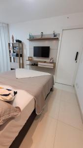 里约热内卢Meu Resort no Recreio - RJ的一间卧室设有两张床,墙上配有电视。