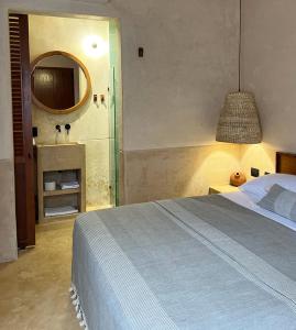坎佩切Bajo las Hojas的一间带一张床的卧室和一间带镜子的浴室