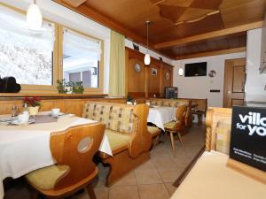 索尔登Haus Daniela的餐厅设有2张桌子和椅子以及窗户。