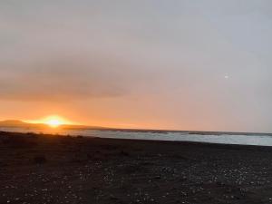 通戈伊Cabañas ecológicas Tongoy的海滩上的日落,背景是大海