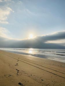 通戈伊Cabañas ecológicas Tongoy的阳光在海洋上空升起的海滩