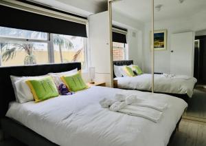 悉尼Spectacular Views of Sydney Harbour with Free Parking的一间卧室配有两张带毛巾和镜子的床