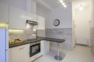 布达佩斯City Centre Apartment with 3 Bathrooms的厨房配有柜台和墙上的时钟