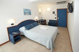 卡托利卡托雷塔酒店的一间卧室配有一张蓝色床头板的床