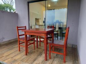 圣罗克迪米纳斯Pousada Colina da Canastra的一张木桌、两把椅子、一张桌子和一张桌子以及一张椅子。