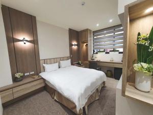 台北葛瑞丝商旅敦北馆的卧室设有一张白色大床和一扇窗户。