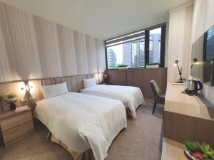 台北葛瑞丝商旅敦北馆的酒店客房设有两张床和窗户。