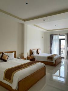土龙木市BĂNG BOUTIQUE HOTEL的酒店客房设有两张床和窗户。