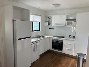 努萨维尔努萨湖泊度假酒店的白色的厨房配有冰箱和水槽