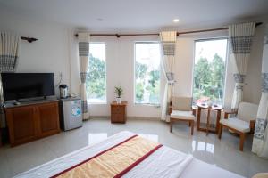 Vị ThanhKhách Sạn Bông Sen的一间卧室配有一张床和一台电视,部分设有窗户。