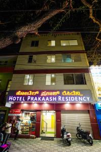 迈索尔HOTEL PRAKAASH RESIDENCY的停在酒店前面的摩托车药店