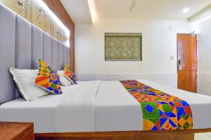 艾哈迈达巴德FabHotel Royal King的一间卧室配有带色彩缤纷枕头的床