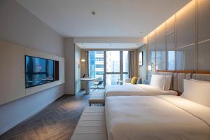 重庆重庆朝天门voco酒店的酒店客房设有三张床和电视。
