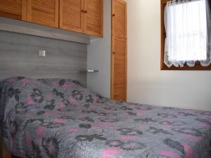 丰罗默奥代洛维亚Chalet Font-Romeu-Odeillo-Via, 5 pièces, 6 personnes - FR-1-580-39的一间卧室配有一张带鲜花毯子的床